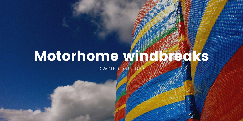 Motorhome parked up at a campsite, windbreak erected.