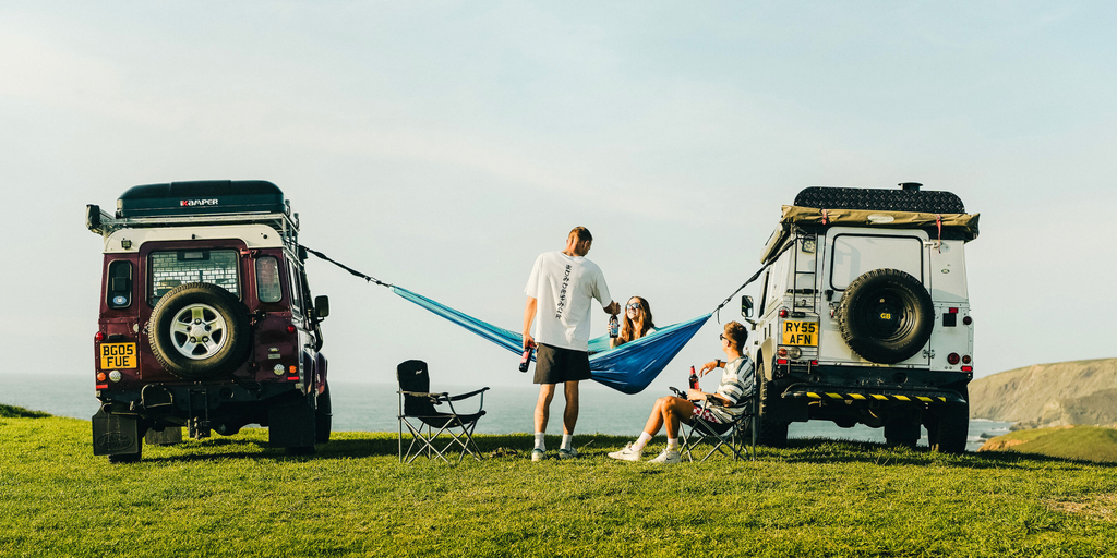 Campervan parked on a sunny beach, evoking warm weather travel and outdoor adventures.