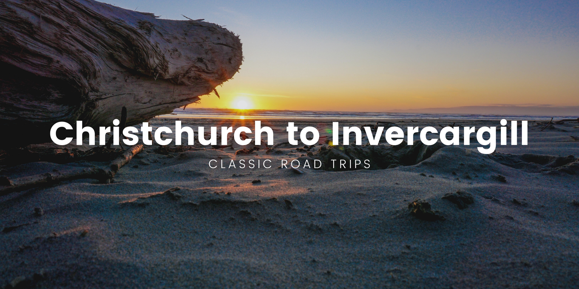 South Island road trip: Campervan overlooking snowy mountains, near a turquoise lake.