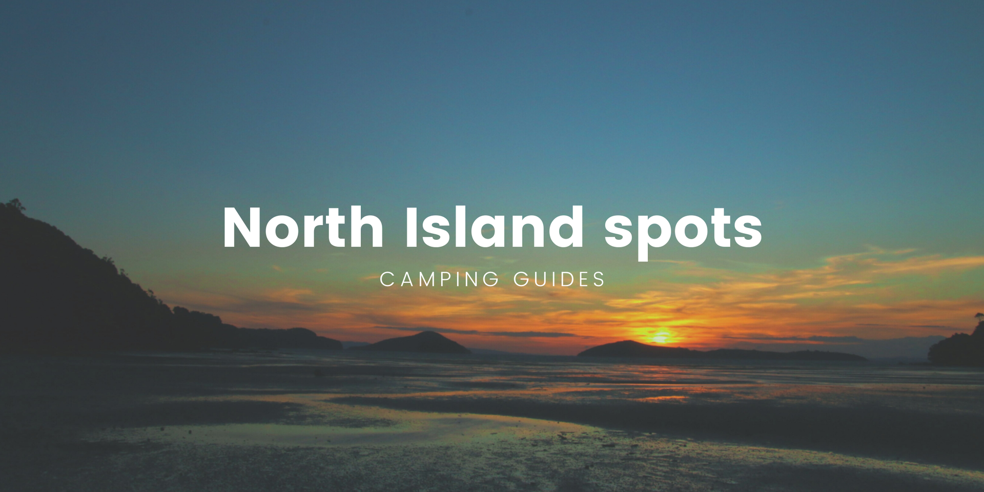 Tents pitched at a campground by a teal lake, North Island scenery.