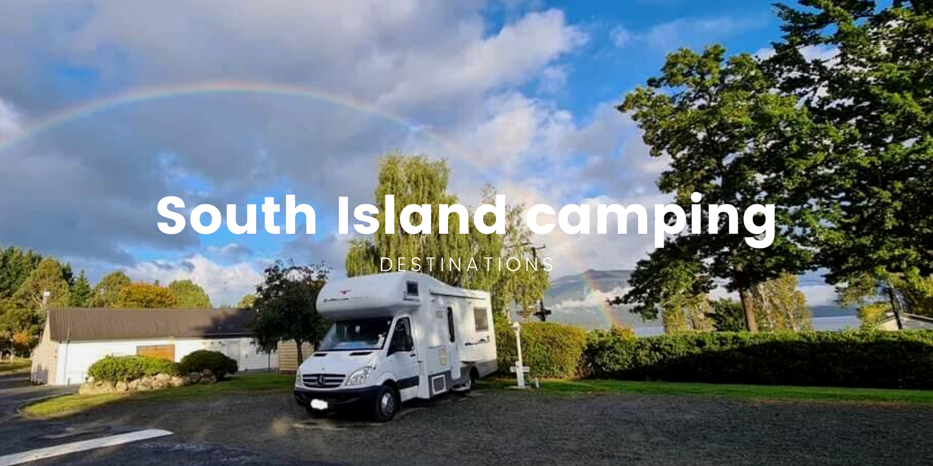 Caravan parked at scenic South Island holiday park, with mountains in the background.
