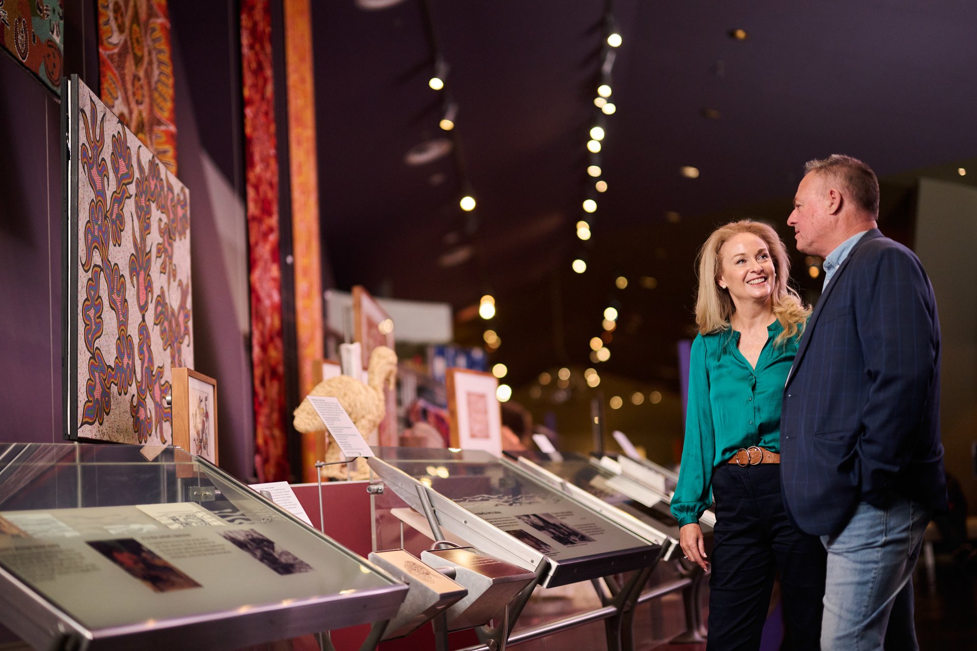 A man and woman looking at an exhibition in a museum