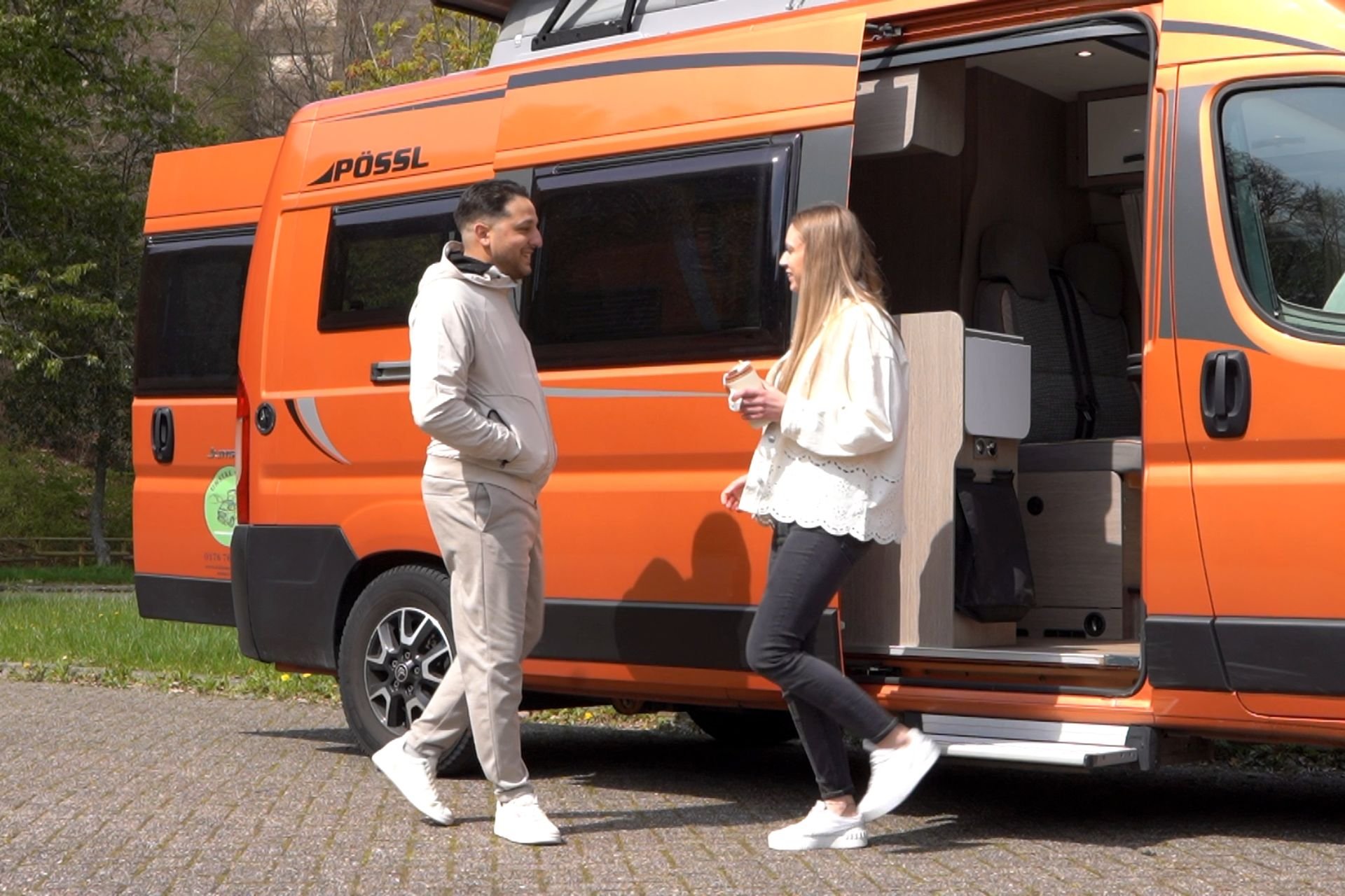 Heller Wohnwagen auf einem sonnigen Stellplatz, bereit für Dein nächstes Camping-Abenteuer.