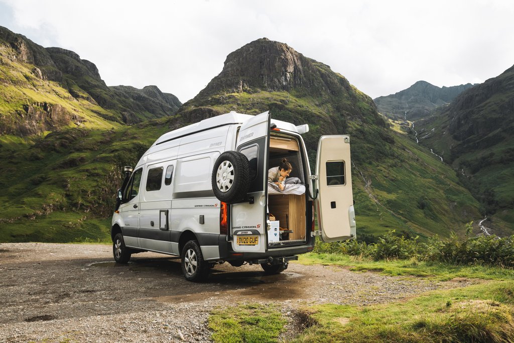 Autocaravana estacionada en camping al atardecer. Viajes, vacaciones y libertad.