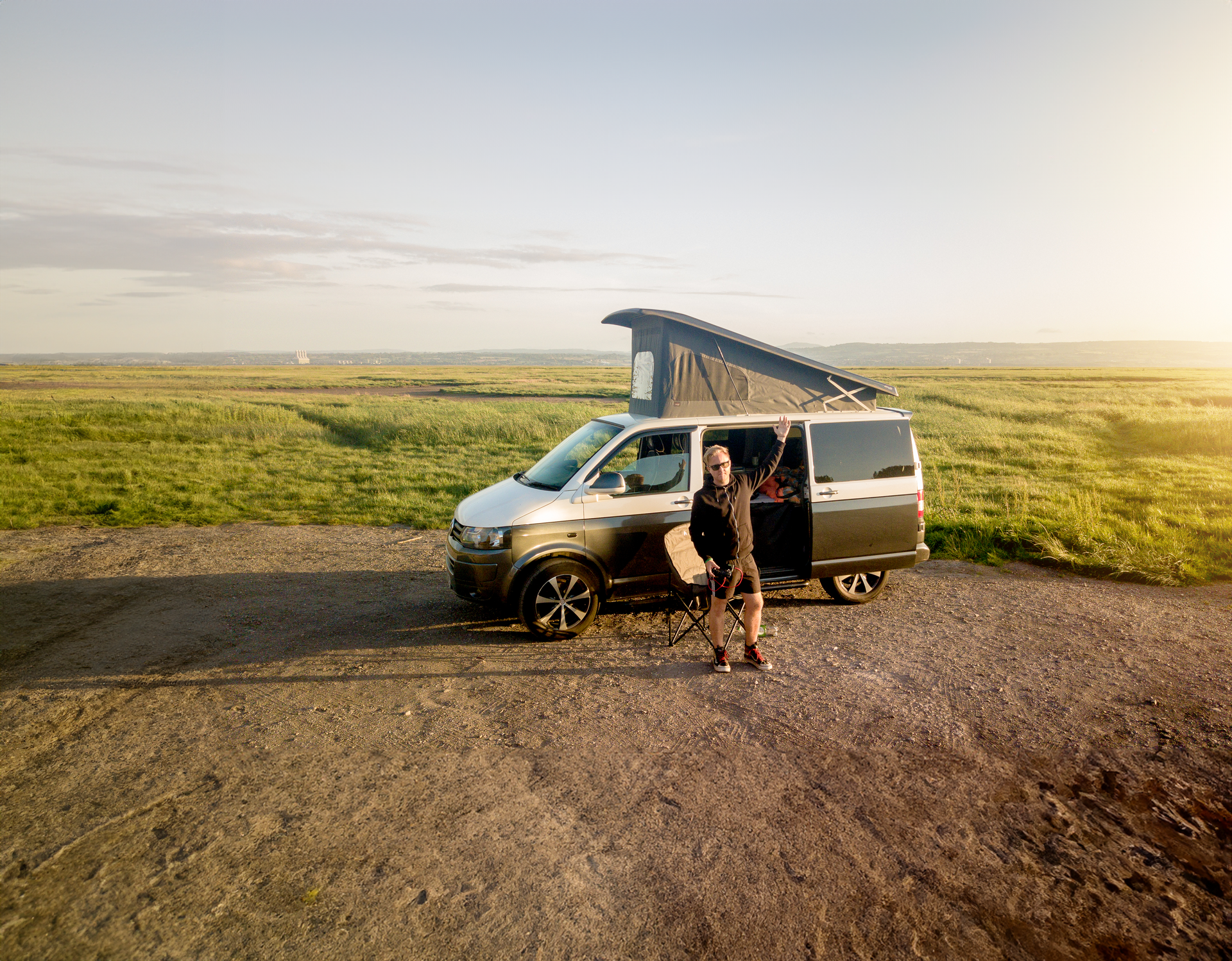 Autocaravana estacionada en la naturaleza con montañas al fondo, representando un viaje de caravaning sostenible.