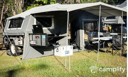 Camper trailer set up at a sunny Queensland campsite, ready for summer adventures.
