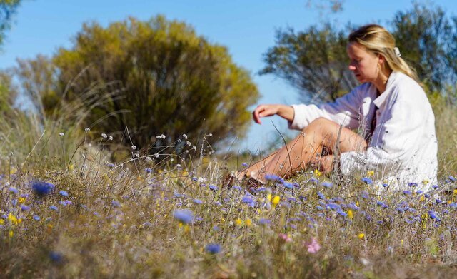 A woman sitting in a field of wildflowers
