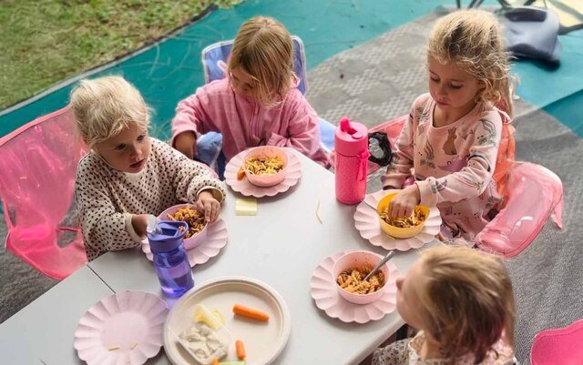Children sitting down at a table eating lunch
