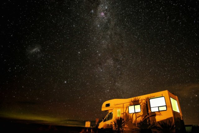 A motorhome parked under the stars at night