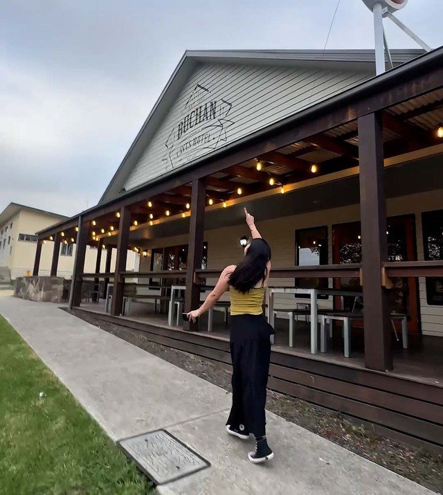 A woman pointing at a restaurant