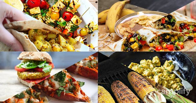 Family camping with tent, campfire & healthy food spread out on picnic rug.