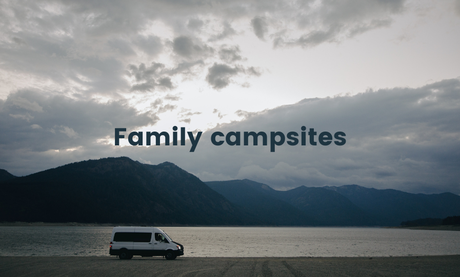 Family pitched tent at scenic campsite, UK. Camping holiday with children.