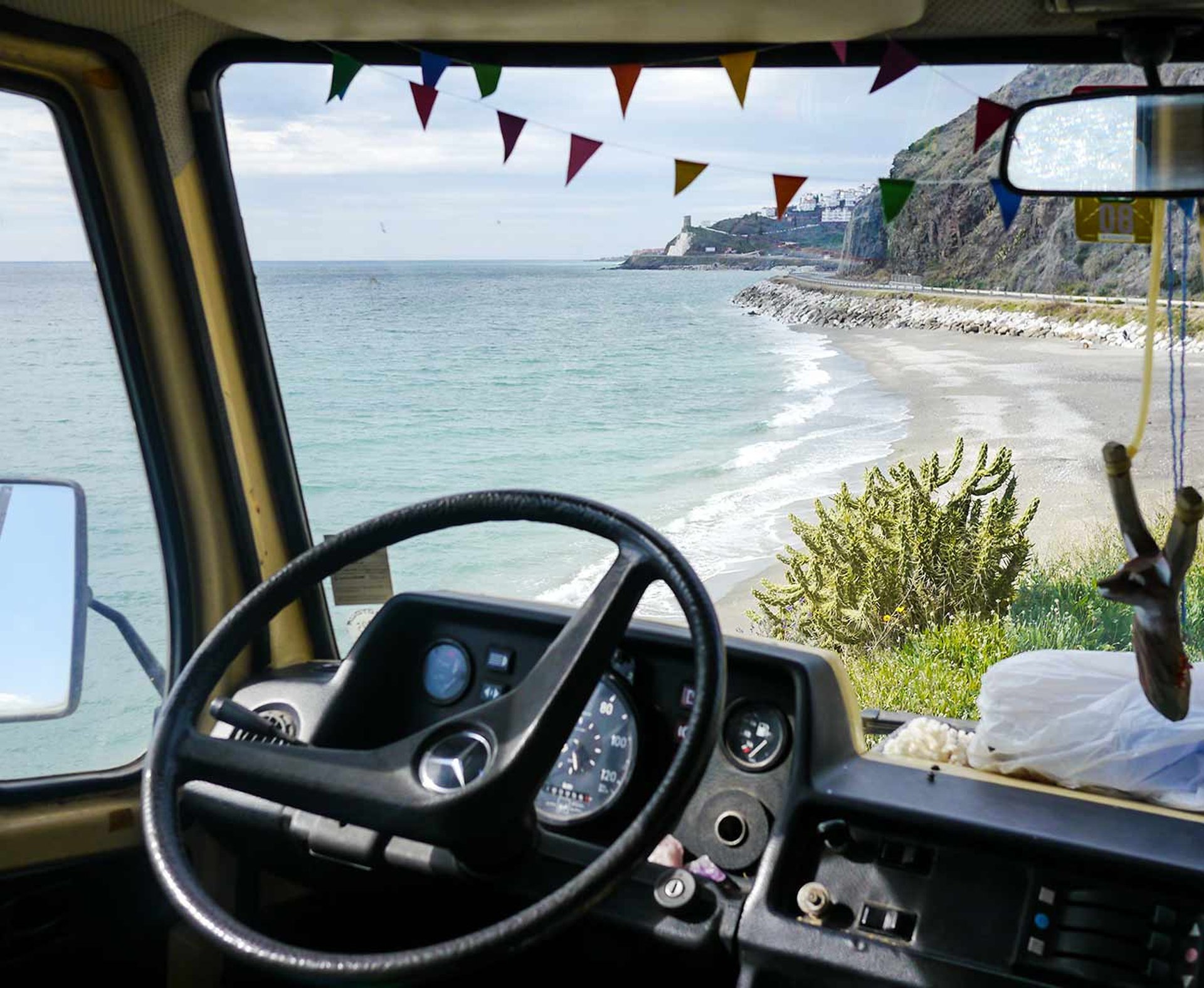 Ausblick aus dem Fahrerraum auf Meer und Kueste Lenkrad Steuer Mercedes