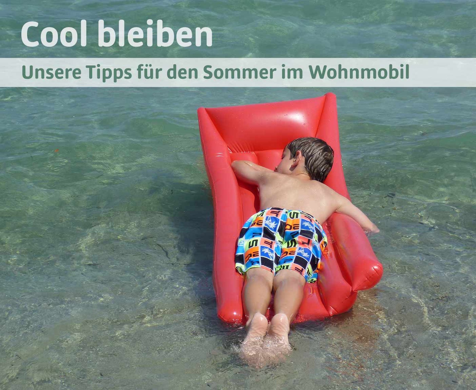 kleiner Junge auf einer roten Luftmatratze schwimmt im Meer