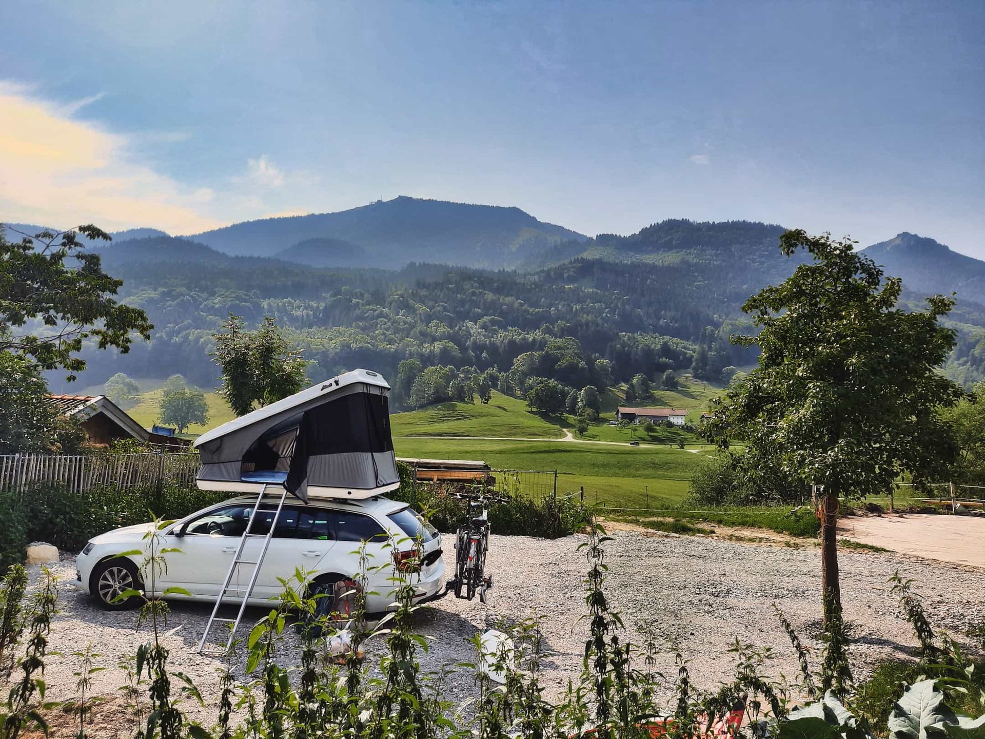 Urlaub auf dem Bauernhof Berge Auto mit Dachzelt Campingurlaub