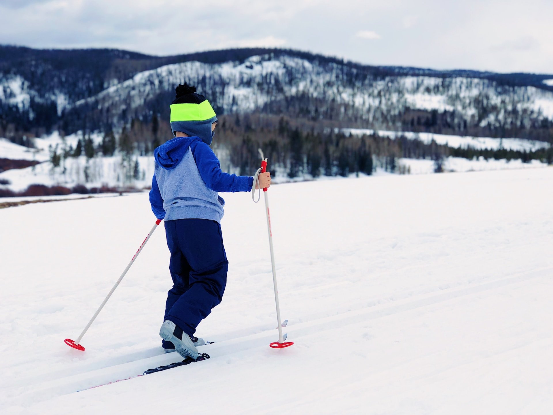 Kind fährt Ski in Winterlandschaft