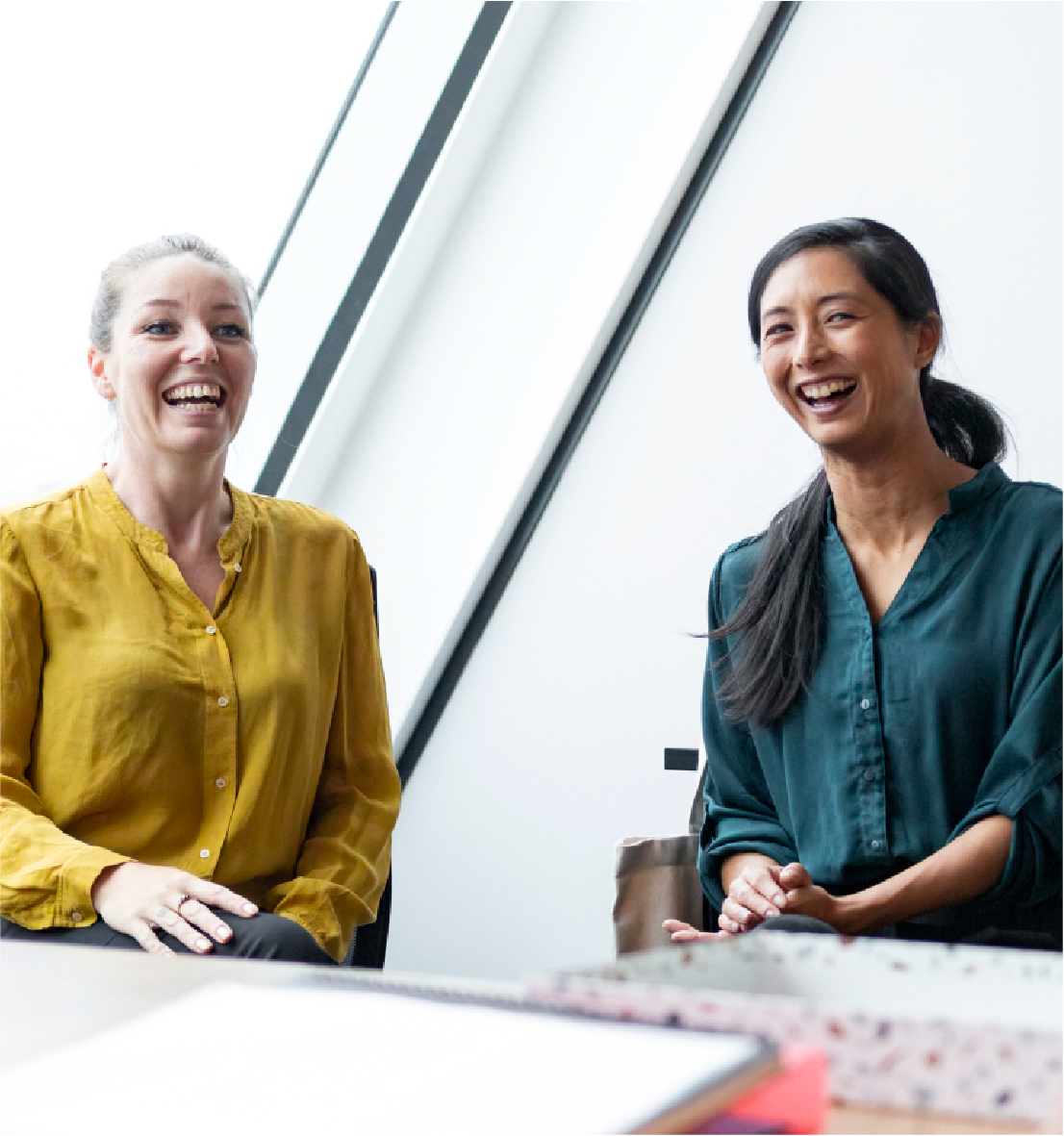Two women laughing in a meeting