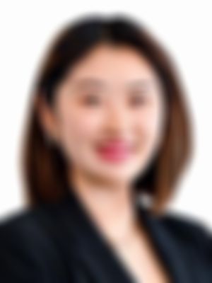 Cherie Chen smiling, wearing a black blazer and earrings, against a white background.
