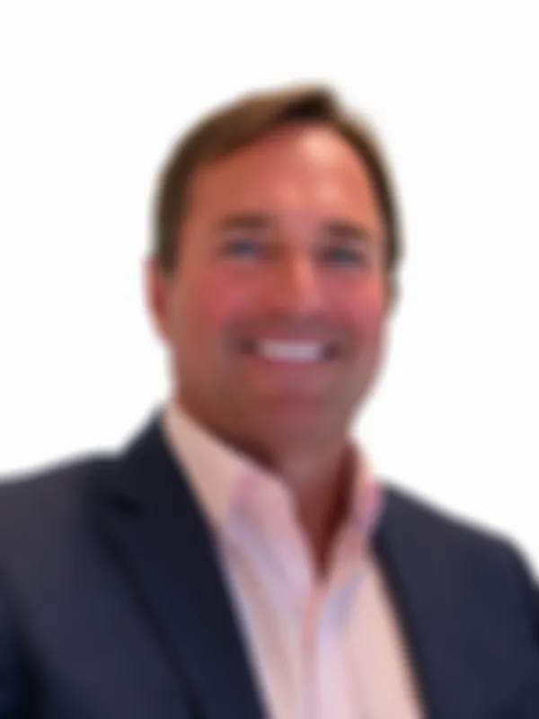 Philip Rofe in a dark suit and light pink shirt against a white background.