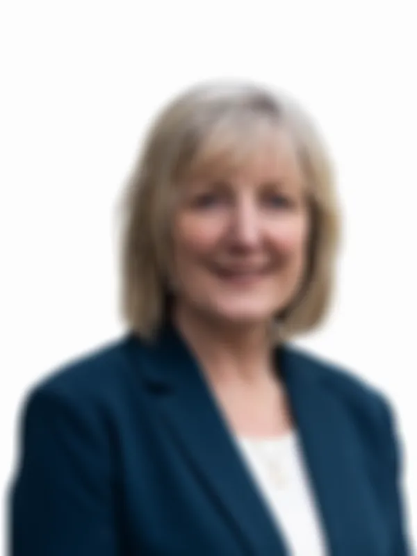 Carolyn Mackay with shoulder-length blond hair, wearing a dark blazer and a white top, isolated on a white background.