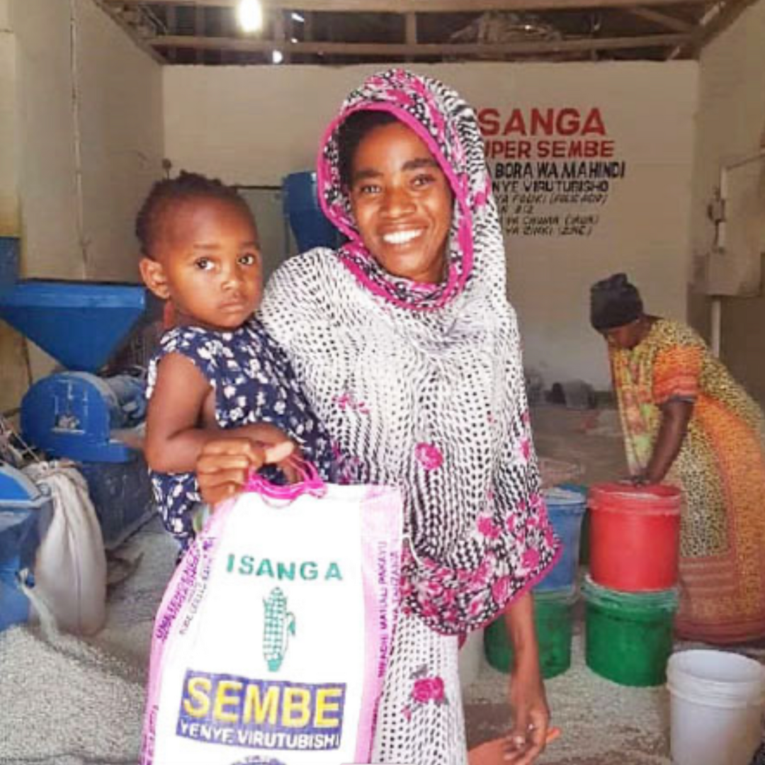 Woman holding child and carrying a bag of rice