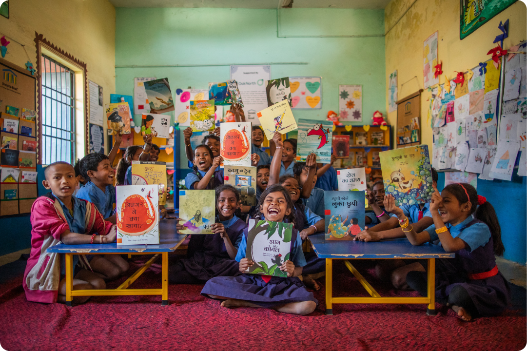 Room to Read students holding up books and smiling