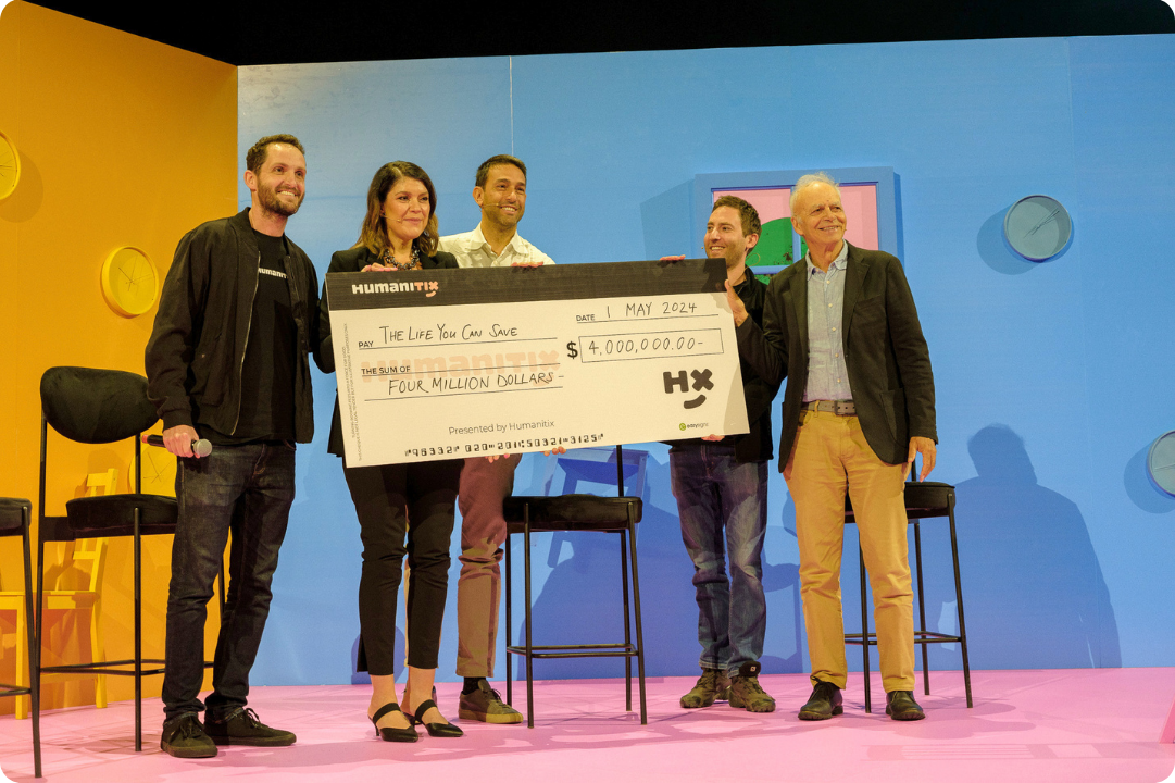Humanitix founders Adam Josh giving The Life You Can Save a giant cheque for $4 million AUD