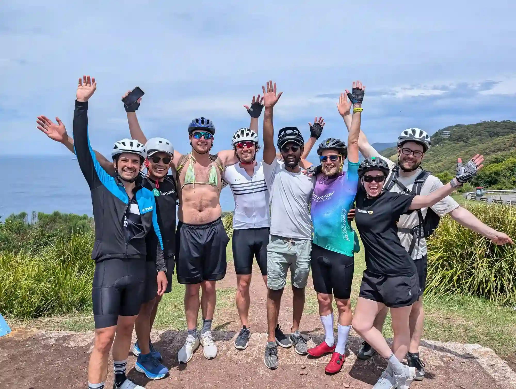 The Humanitix team in cycling gear waving their hands up