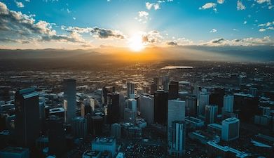 A photo of the sun setting behind the Denver, Colorado city skyline.