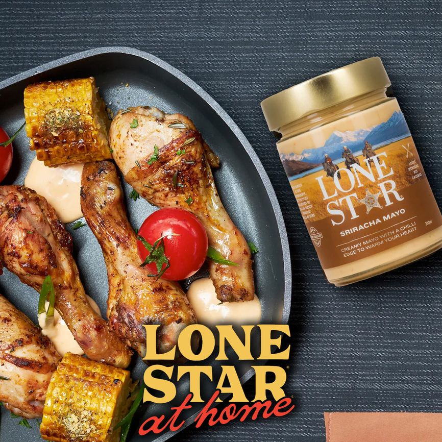 Grilled chicken, corn, and tomatoes in a pan with a jar of Lone Star Sriracha Mayo beside it. Text: "Lone Star at home."