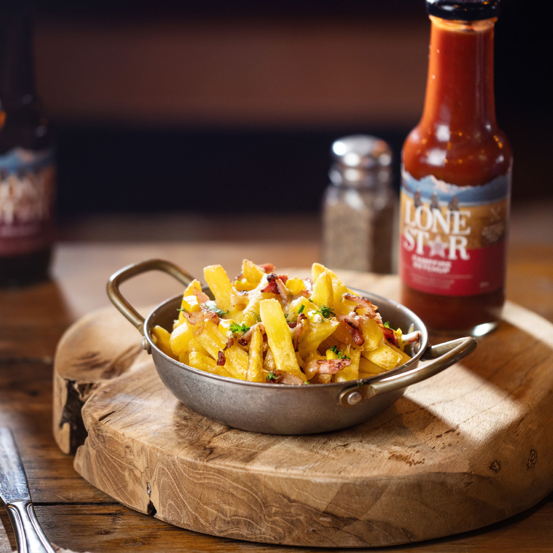 Loaded Dixie Fries from Lone Star NZ topped with bacon, cheese melt, and Dixie sauce – a must-try comfort food from local restaurants near me.