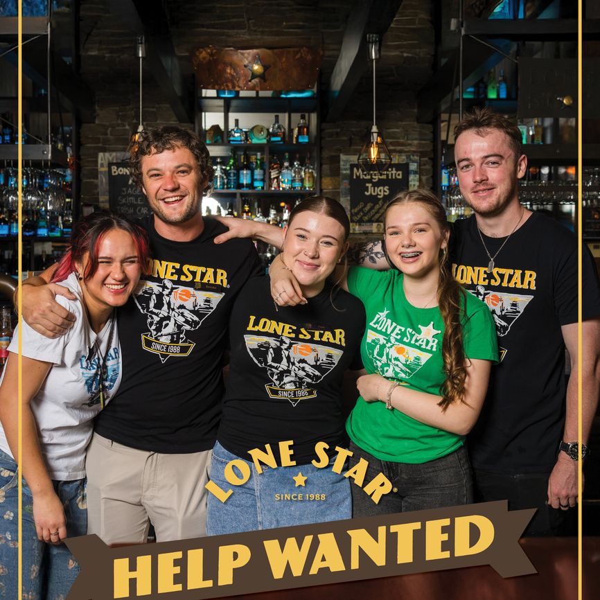 Five smiling people in "Lone Star" shirts pose in a bar with a "Help Wanted" sign at the bottom.
