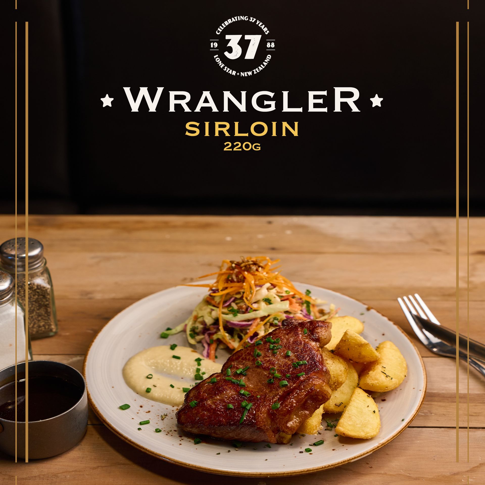 Plate of sirloin steak with potato wedges and coleslaw on a wooden table, accompanied by a drink and condiments. Wrangler Sirloin text overlay.