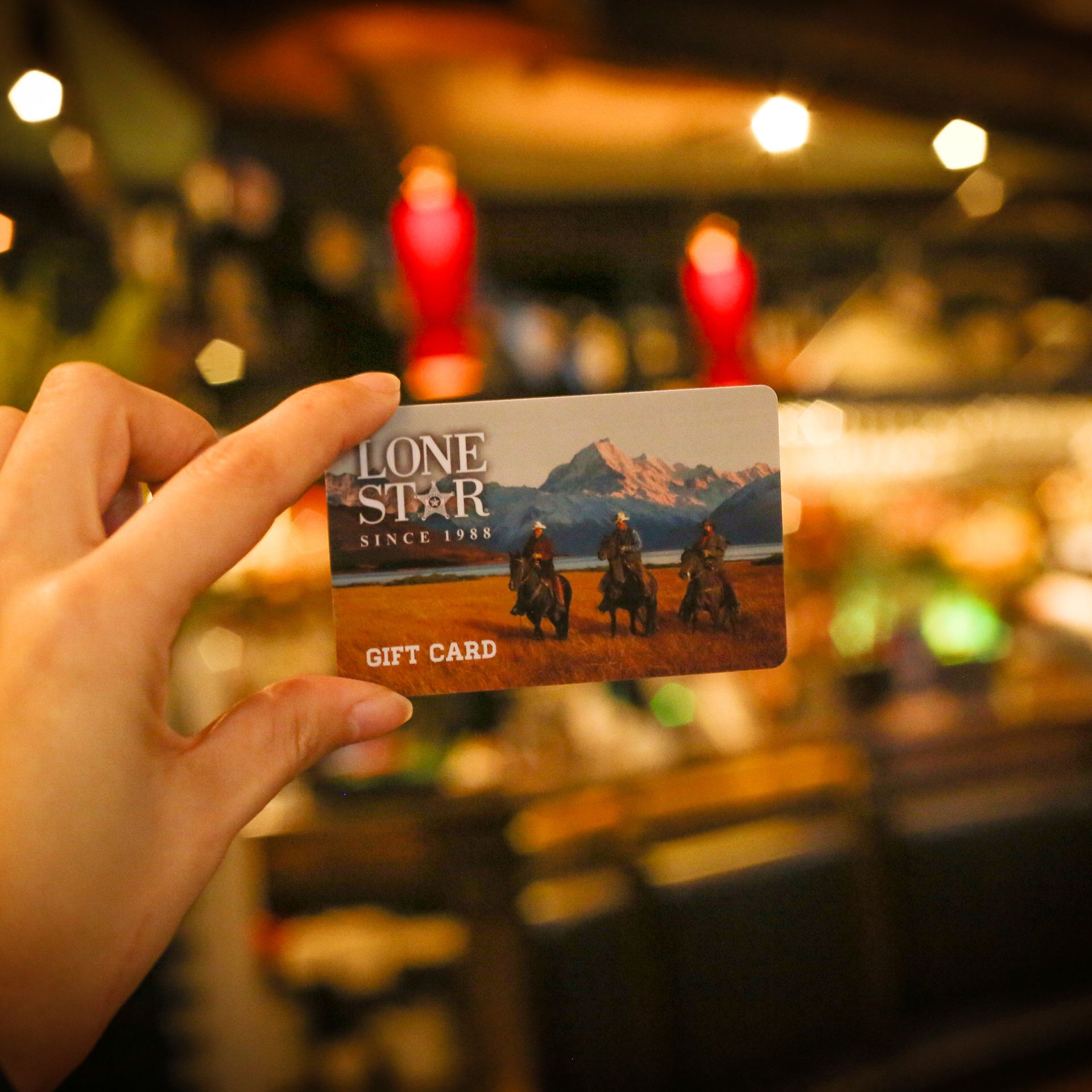 Person holding a Lone Star Gift Card, offering a taste of one of NZ’s favourite restaurants.