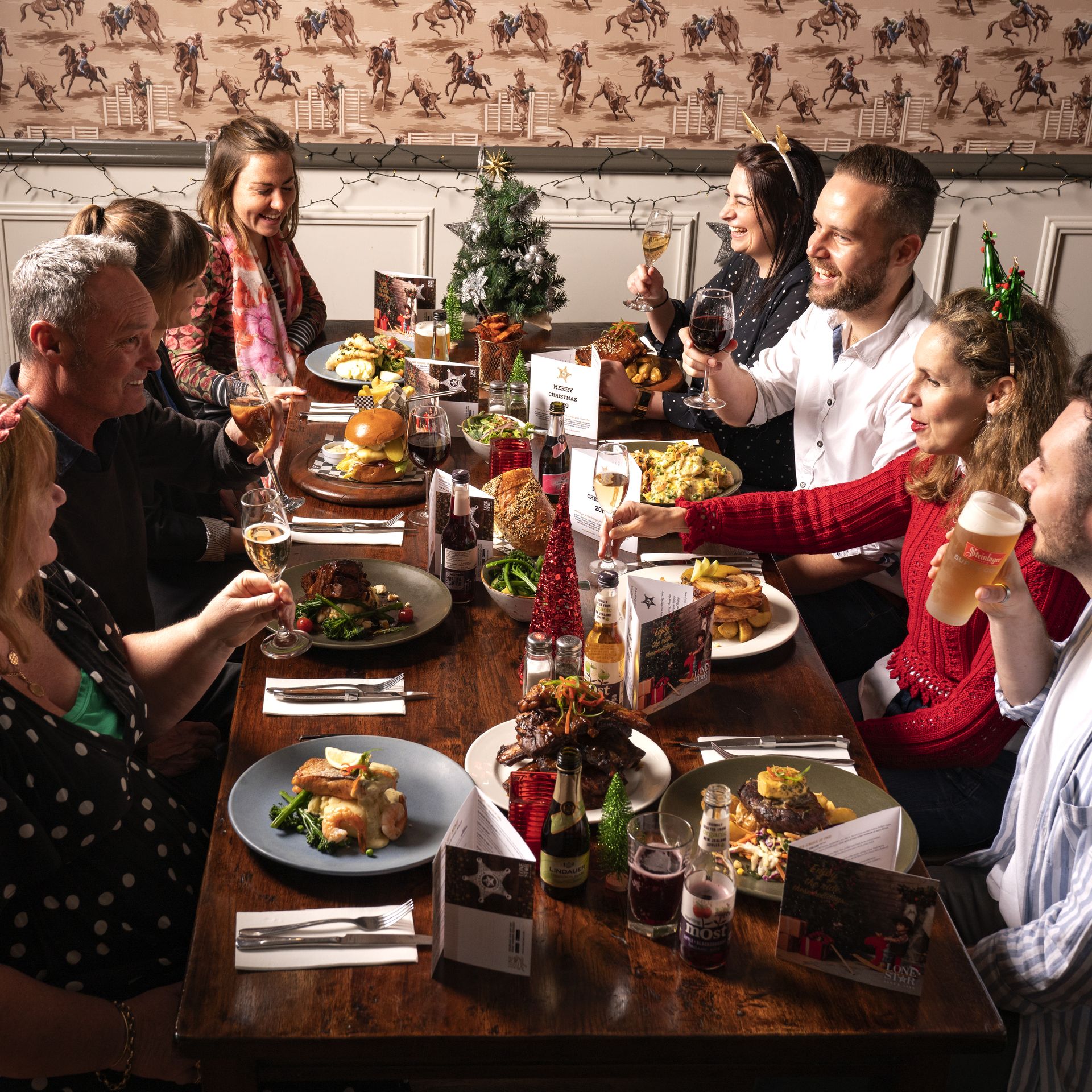 Group of happy work friends enjoying their Christmas celebration at Lone Star NZ.
