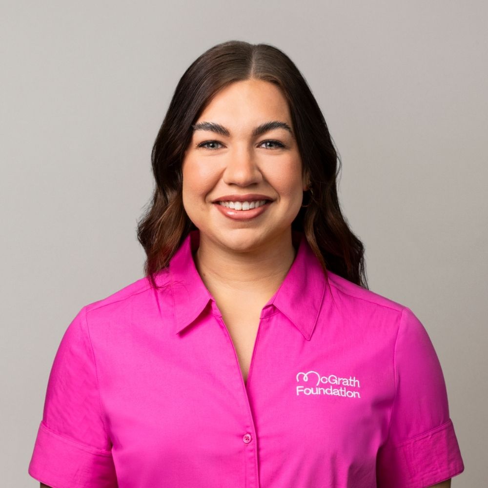 Portrait of Paige Cullin wearing a bright pink McGrath Foundation uniform shirt.