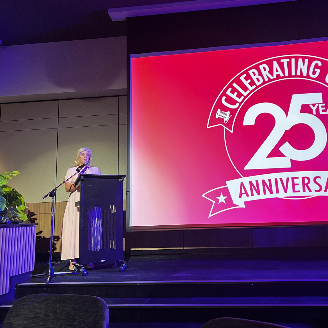 Tracy Bevan giving speech on stage at the 25th Anniversary of Blessington
