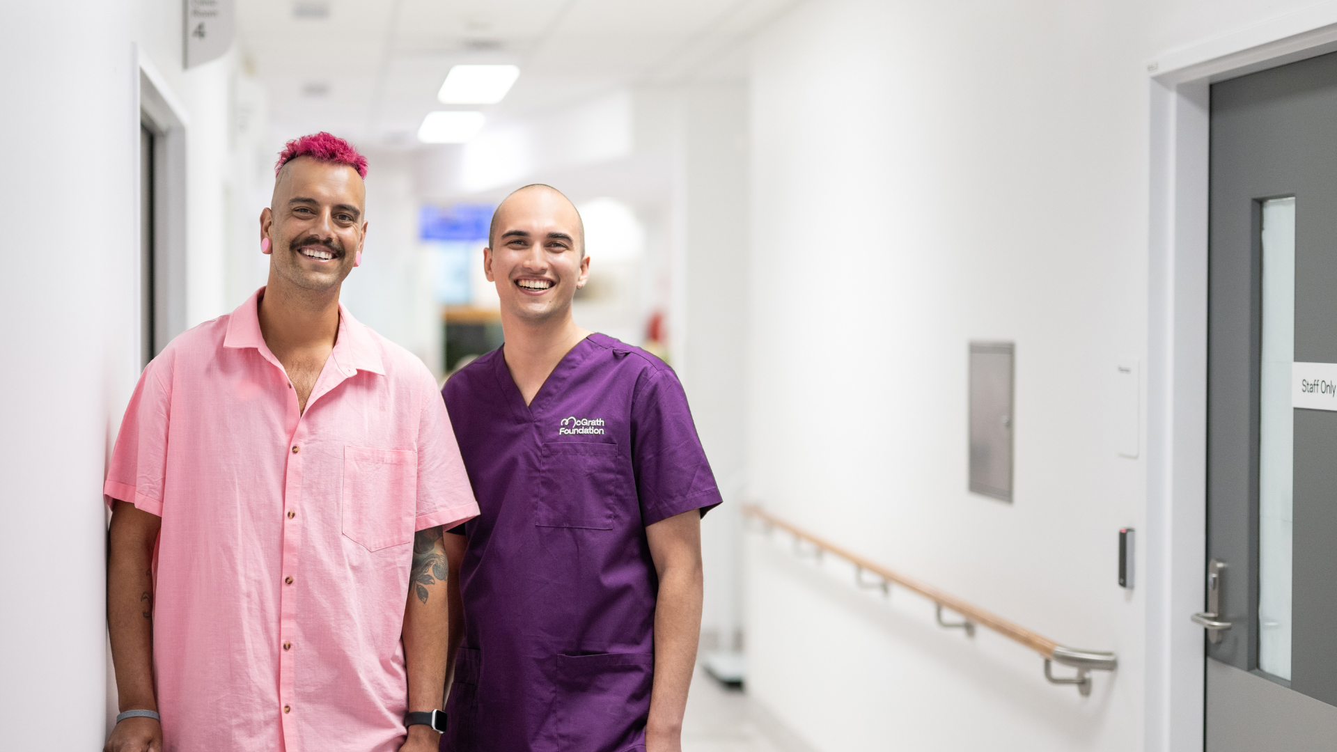 McGrath Cancer Care Nurse standing in the hallway of a medical facility with a patient smiling at the camera