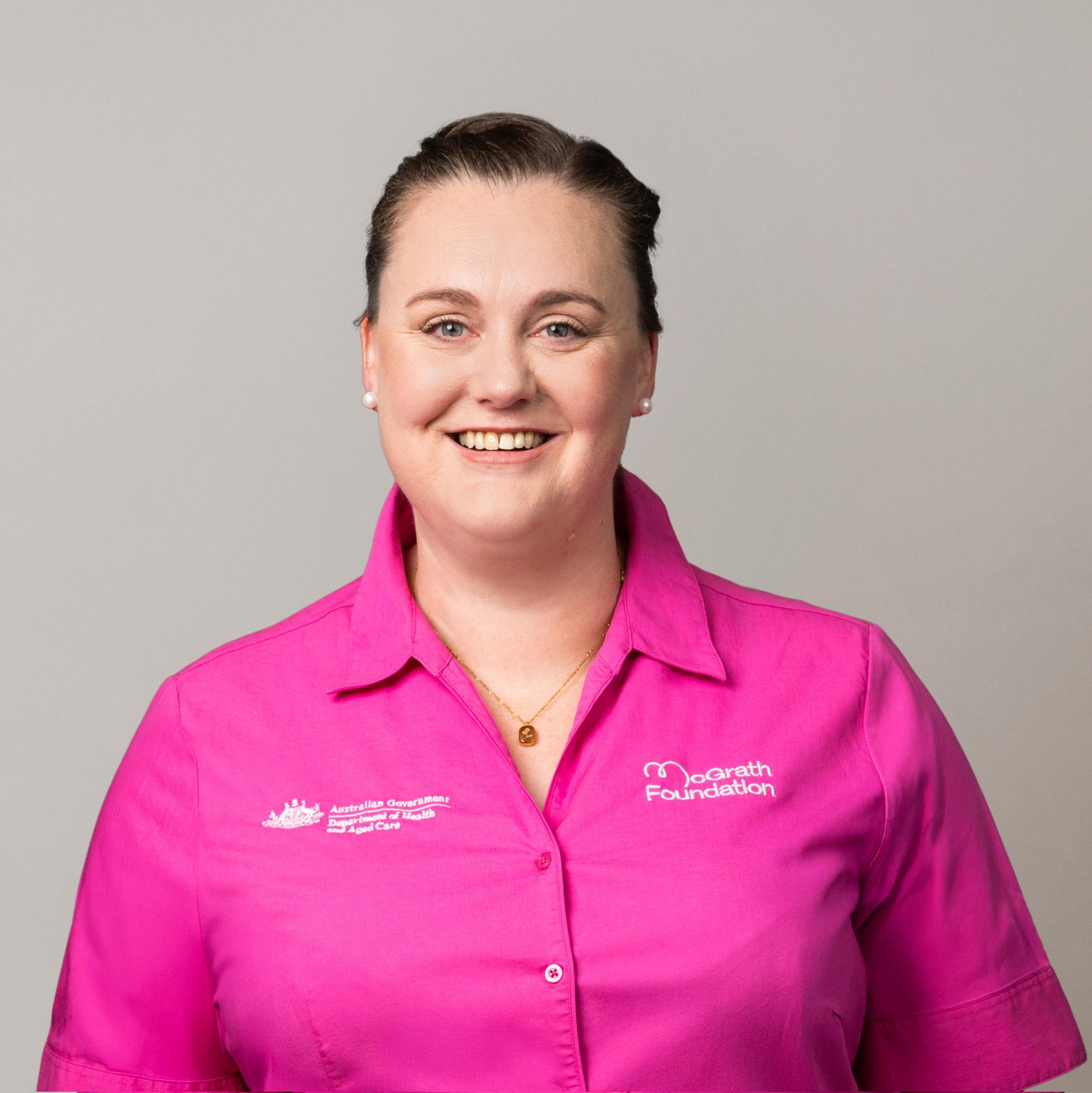 Eva Driver wearing a pink McGrath Foundation shirt against a light grey background