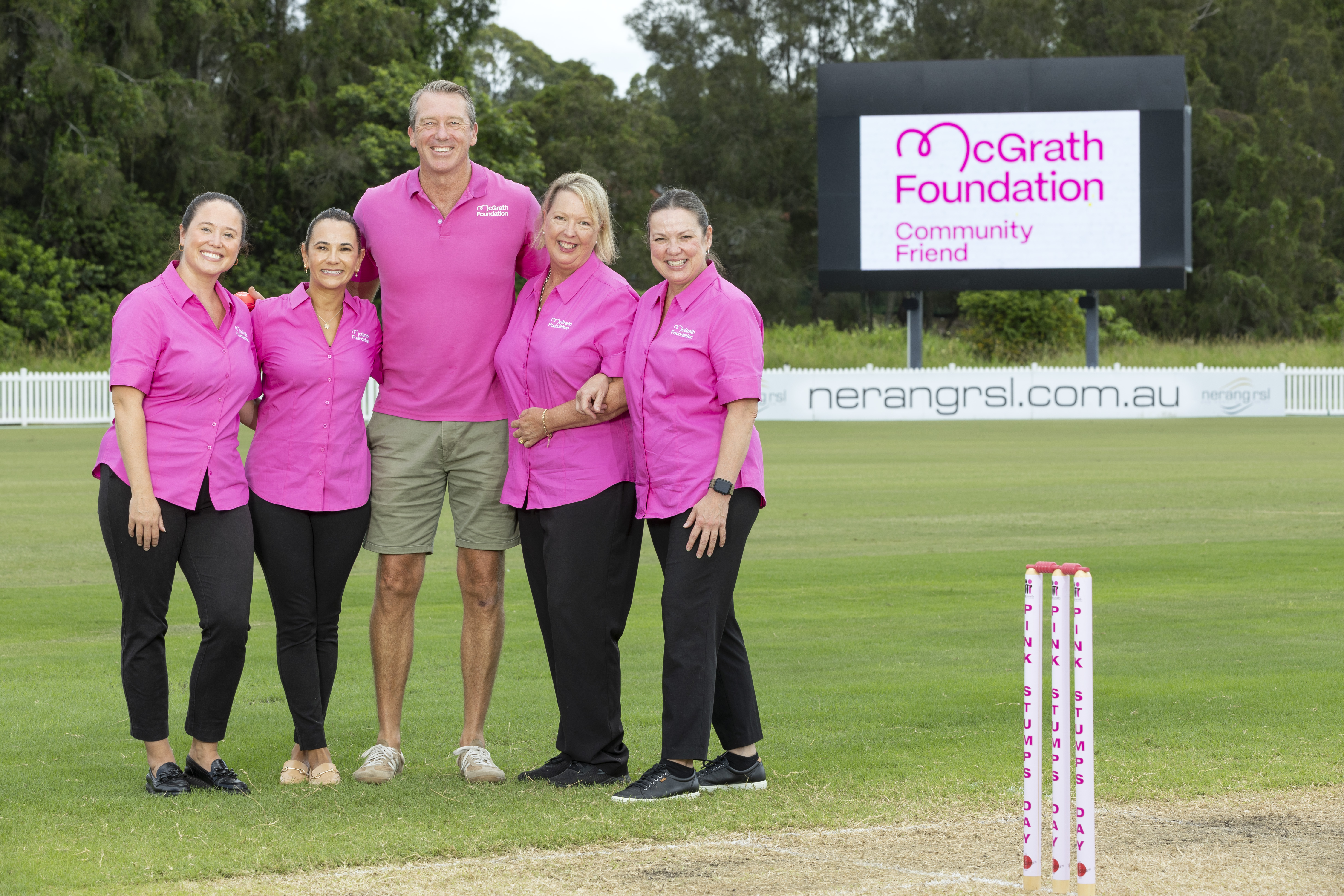 Glenn McGrath standing on a cricket pitch with nurses