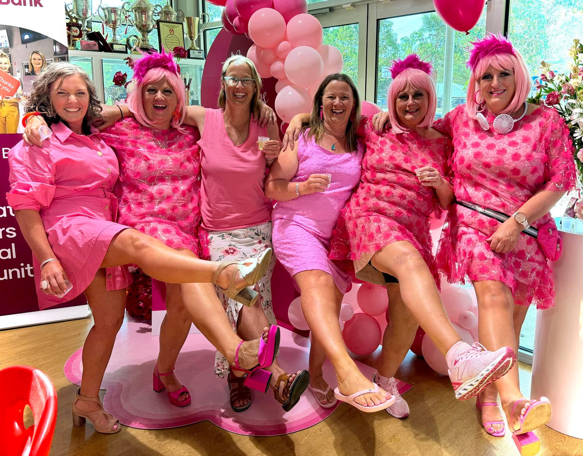 Women in pink with the Warrandyte Pink Ladies at a celebration, kicking their legs.