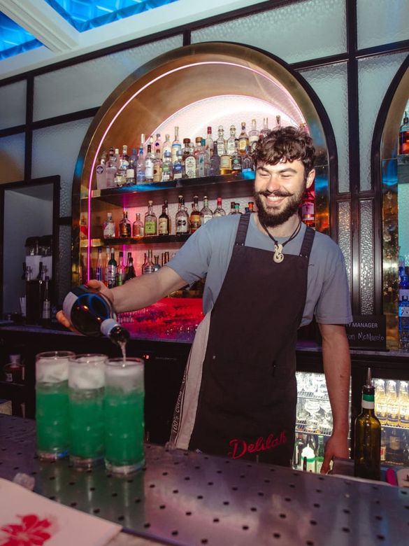 Bartender pouring green drinks at Delilah Bar