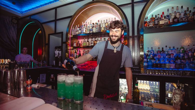 Bartender pouring green drinks at Delilah Bar