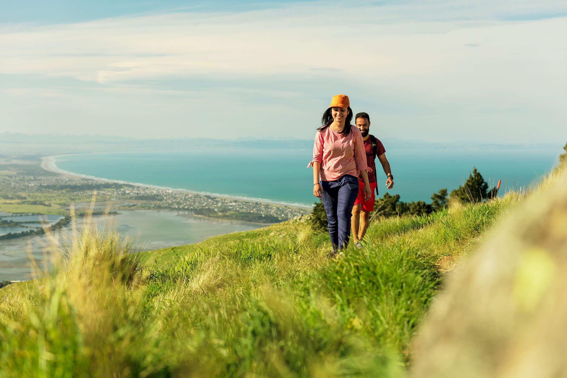 Friends walking in the Port Hills Christchurch with the Christchurch coastline in the background.