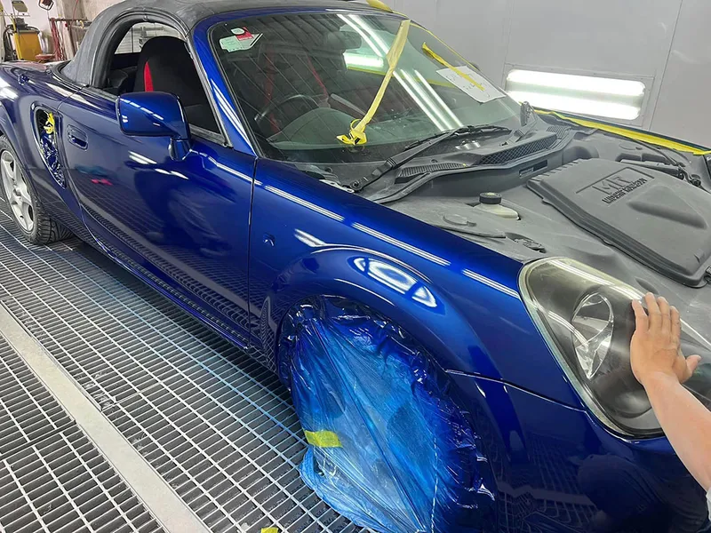 Blue Toyota MR2 masked on the front guard for a spot repair