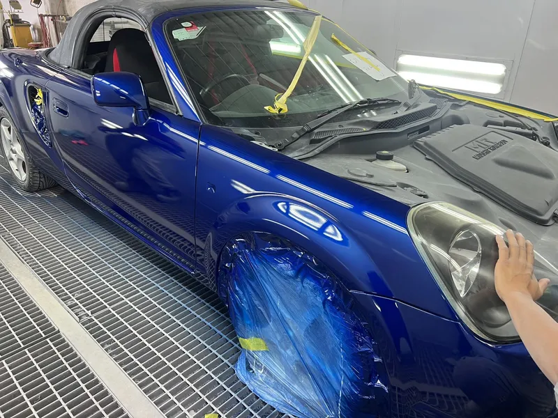 Blue Toyota MR2 masked on the front guard for a spot repair