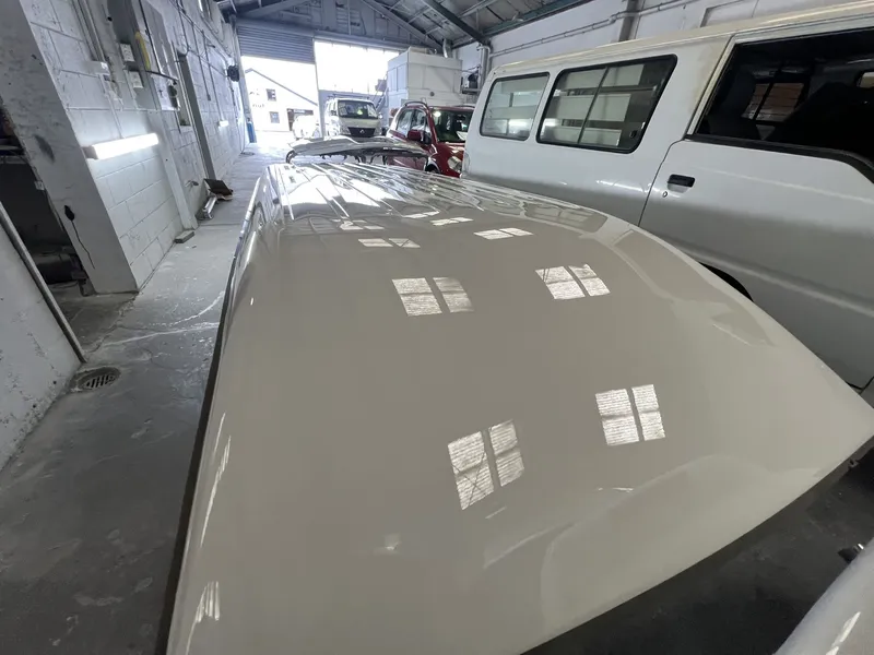 Freshly painted bonnet with a mirror finish reflecting the workshop windows