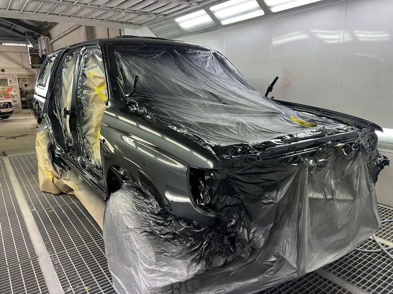 Dark grey Range Rover masked up in the spray booth ready for a repaint