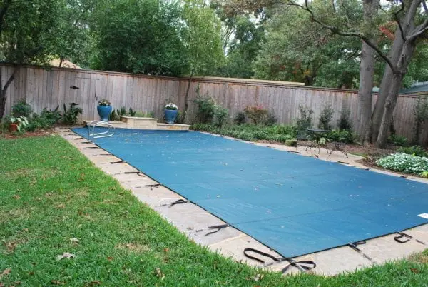 A winter safety cover fitted over a backyard pool