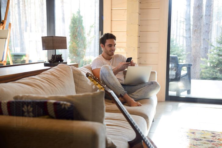 Man checking his loan application progress on his phone and laptop